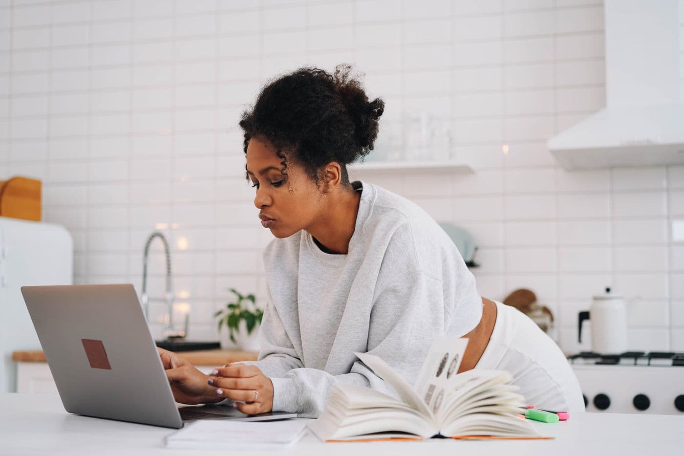 A student at a laptop in a shared workspace, seen from the side